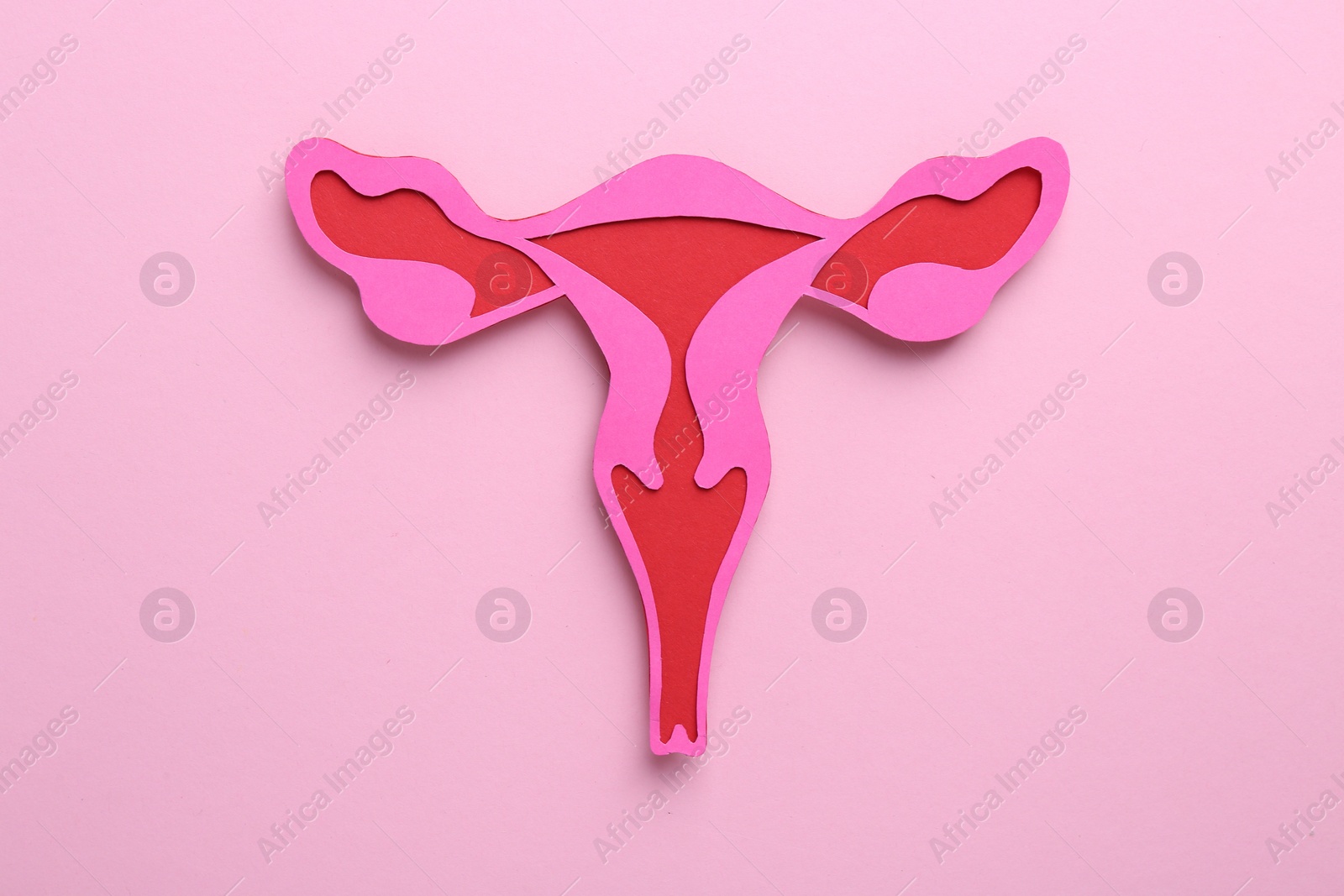 Photo of Reproductive medicine. Paper uterus on pink background, top view