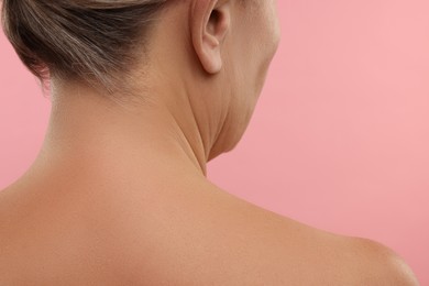 Photo of Mature woman with healthy skin on pink background, closeup