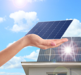 Woman demonstrating solar panel outdoors, closeup. Alternative energy source 