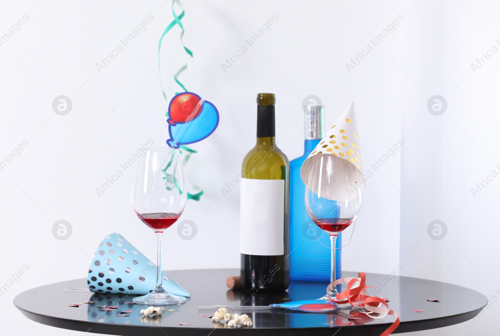 Photo of Messy table with bottles and glasses against white background. After party chaos