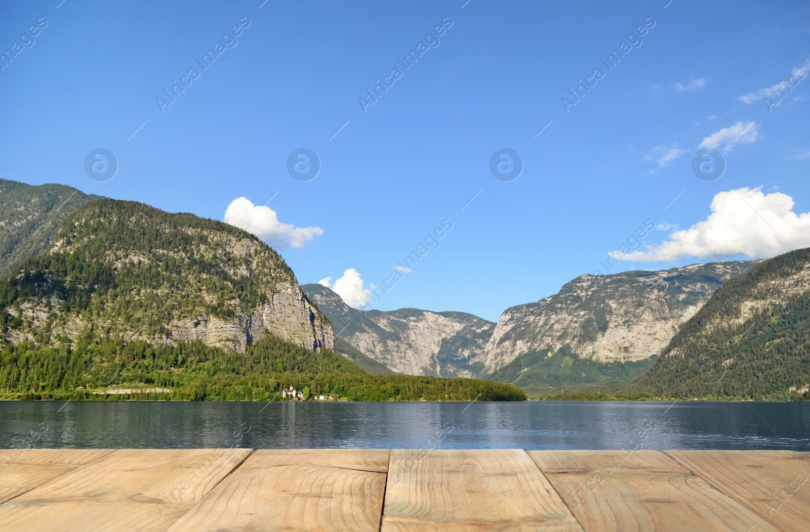 Image of Beautiful view of mountains and wooden pier near lake on sunny day