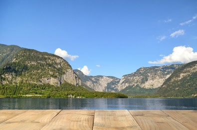 Image of Beautiful view of mountains and wooden pier near lake on sunny day