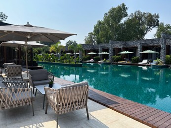 Photo of Outdoor furniture in recreation area near swimming pool at resort
