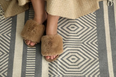 Photo of Woman in fluffy slippers at home, closeup