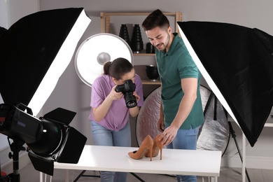 Photo of Professional photographers shooting stylish shoes in studio