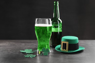 St. Patrick's day celebration. Green beer, leprechaun hat and decorative clover leaves on grey table