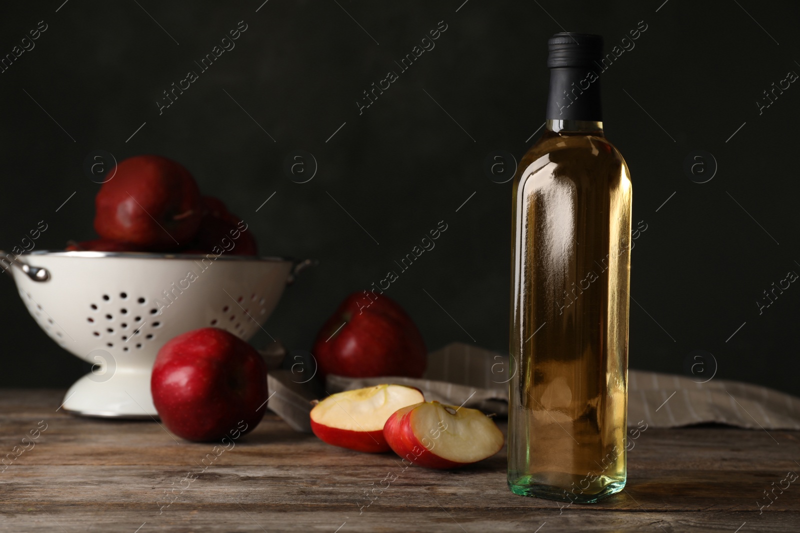 Photo of Composition with bottle of apple vinegar on table. Space for text