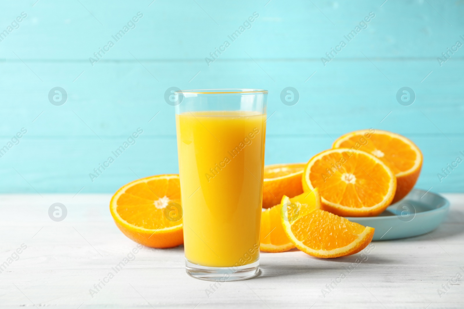 Photo of Glass of orange juice and fresh fruits on white wooden table