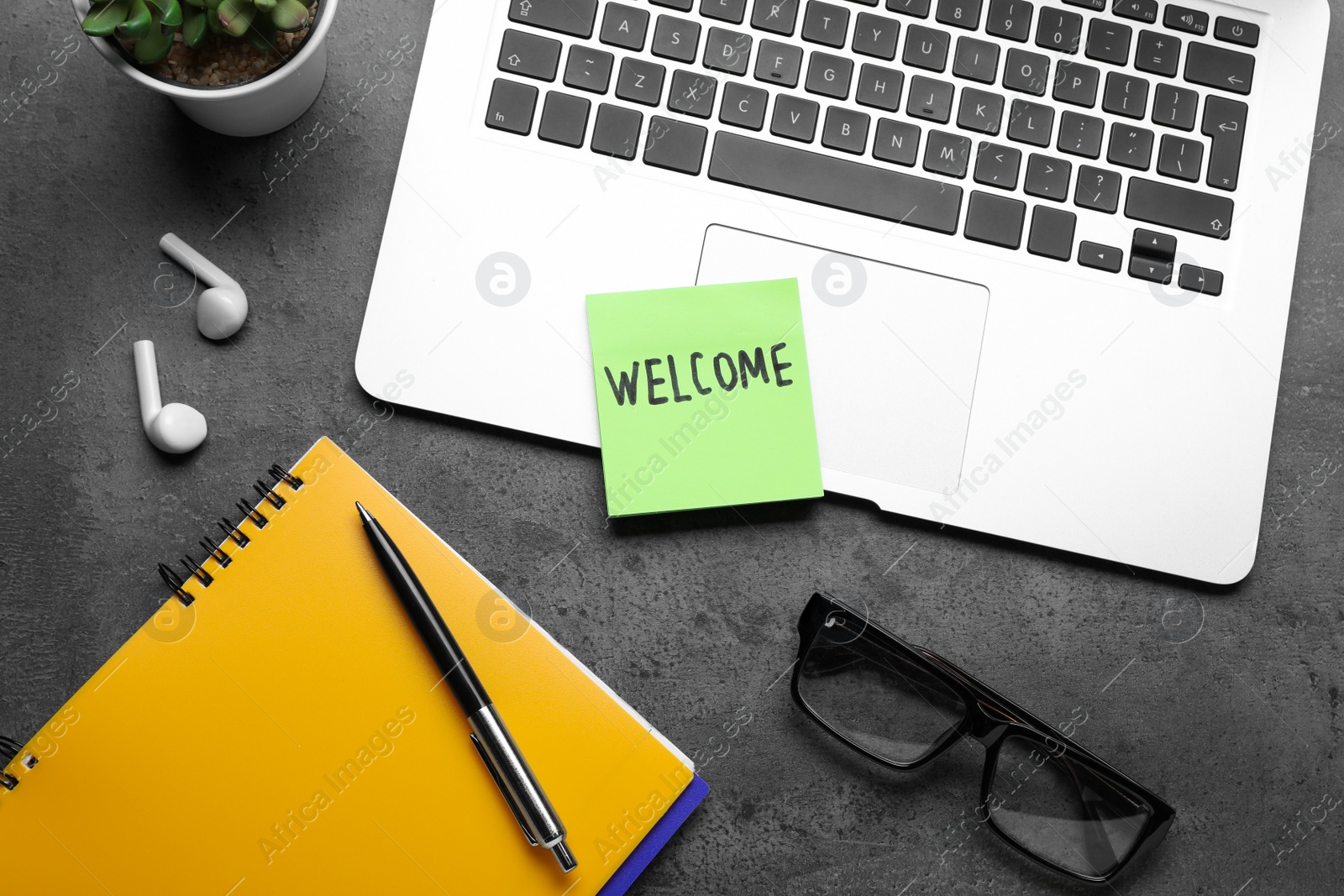 Photo of Flat lay composition of note with word Welcome and gadgets on grey table