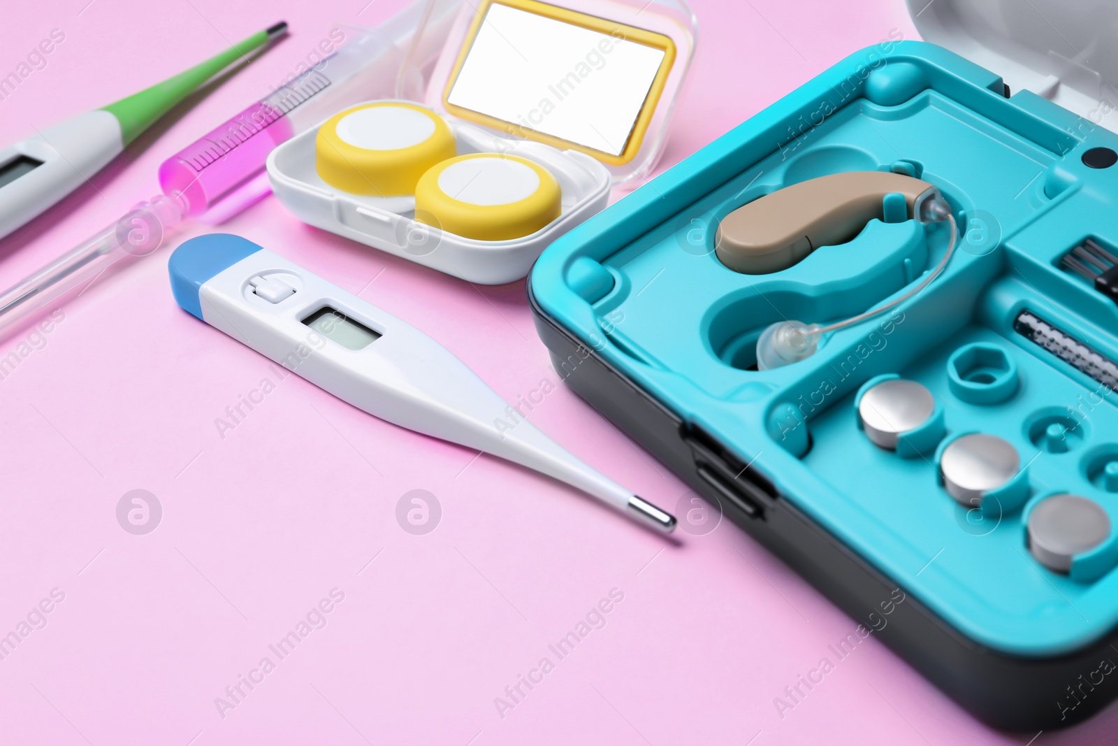 Photo of Hearing aid and medical objects on color background