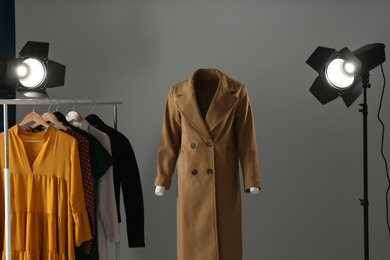 Photo of Ghost mannequin, clothes and professional lighting equipment in modern photo studio