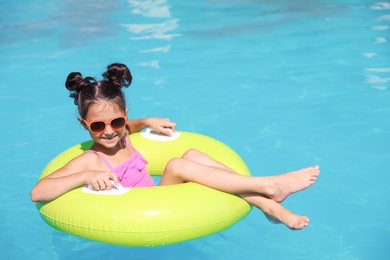 Little girl with inflatable ring in swimming pool