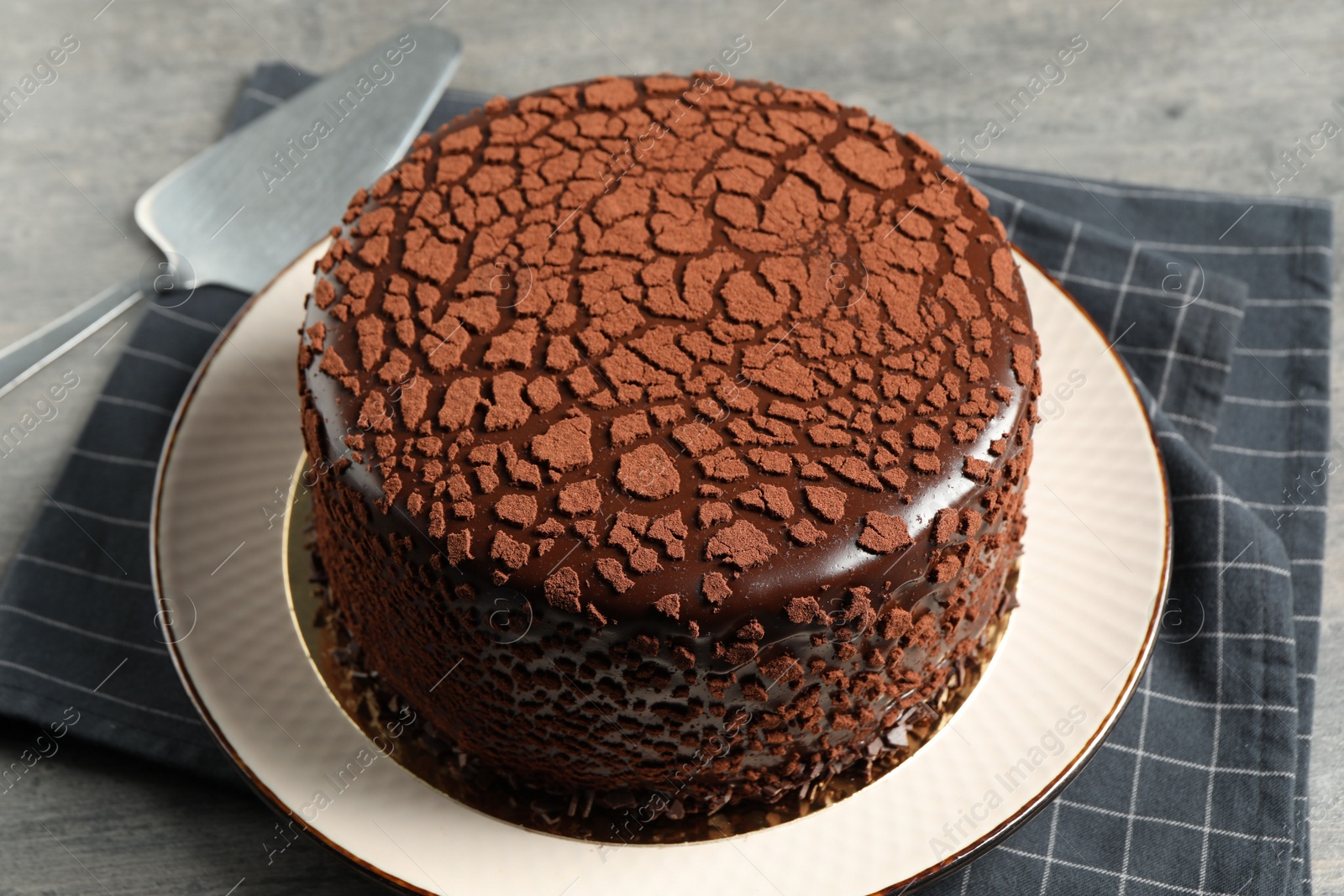 Photo of Delicious chocolate truffle cake and server on table