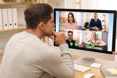 Man having video chat with colleagues at table in office. Team work  