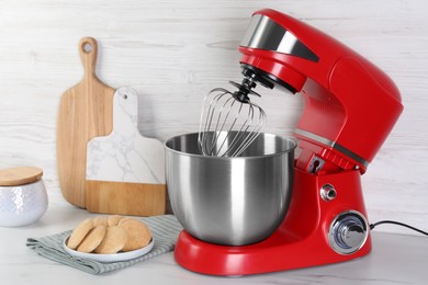 Modern red stand mixer and cookies on white marble table