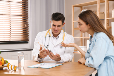 Photo of Nutritionist consulting patient at table in clinic