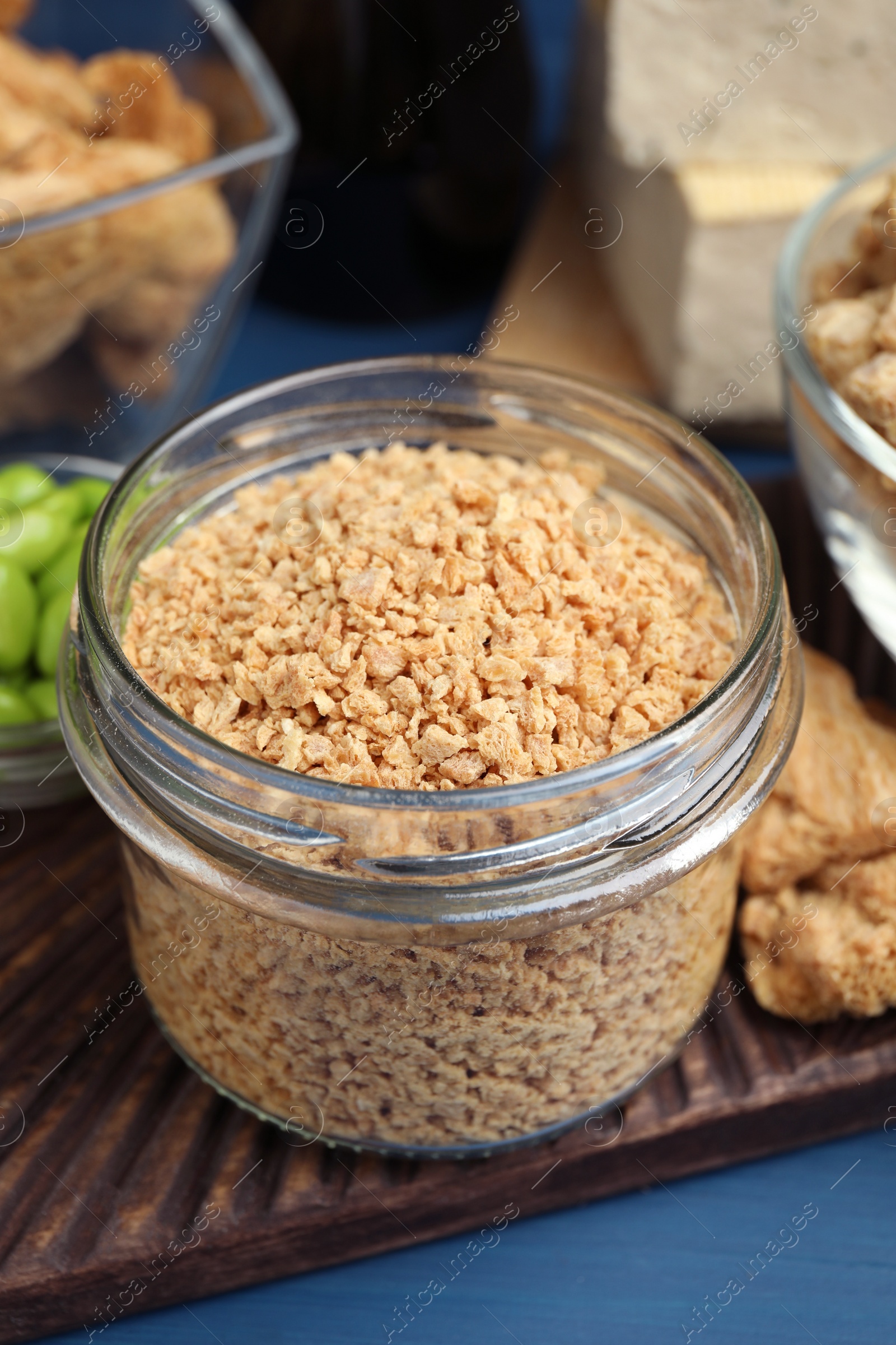 Photo of Dehydrated soy meat and other organic products on blue table, closeup