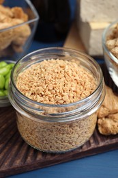 Dehydrated soy meat and other organic products on blue table, closeup