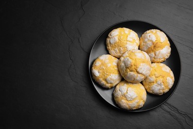 Photo of Plate with delicious lemon cookies on black table, top view. Space for text