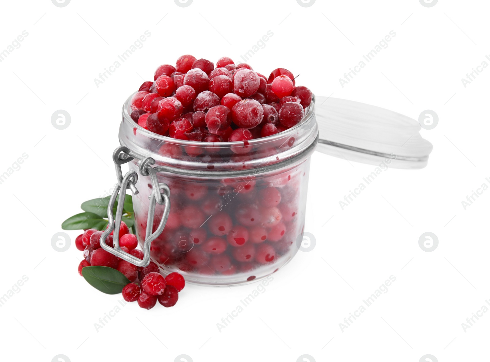 Photo of Frozen red cranberries in glass jar and green leaves isolated on white