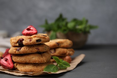 Photo of Cookies with freeze dried fruits, mint and nuts on grey table, closeup. Space for text