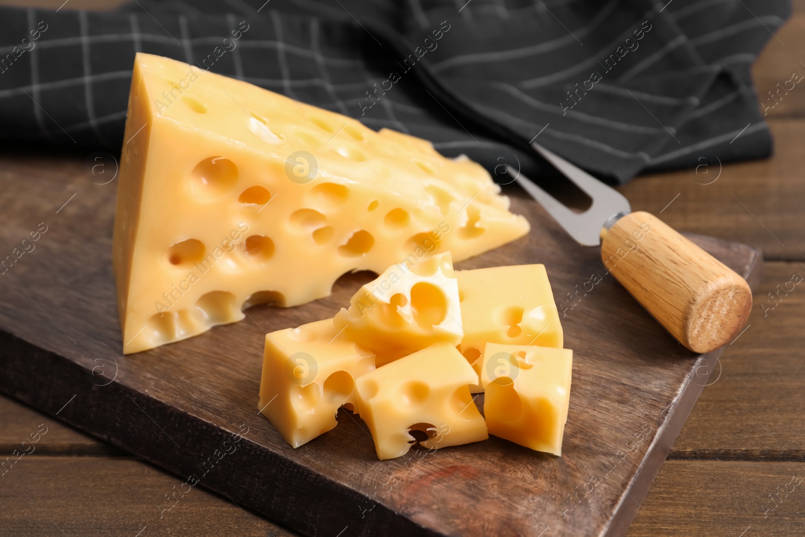 Photo of Tasty fresh cheese with fork on wooden table