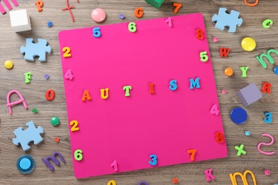 Photo of Flat lay composition with word Autism and colorful letters on wooden table