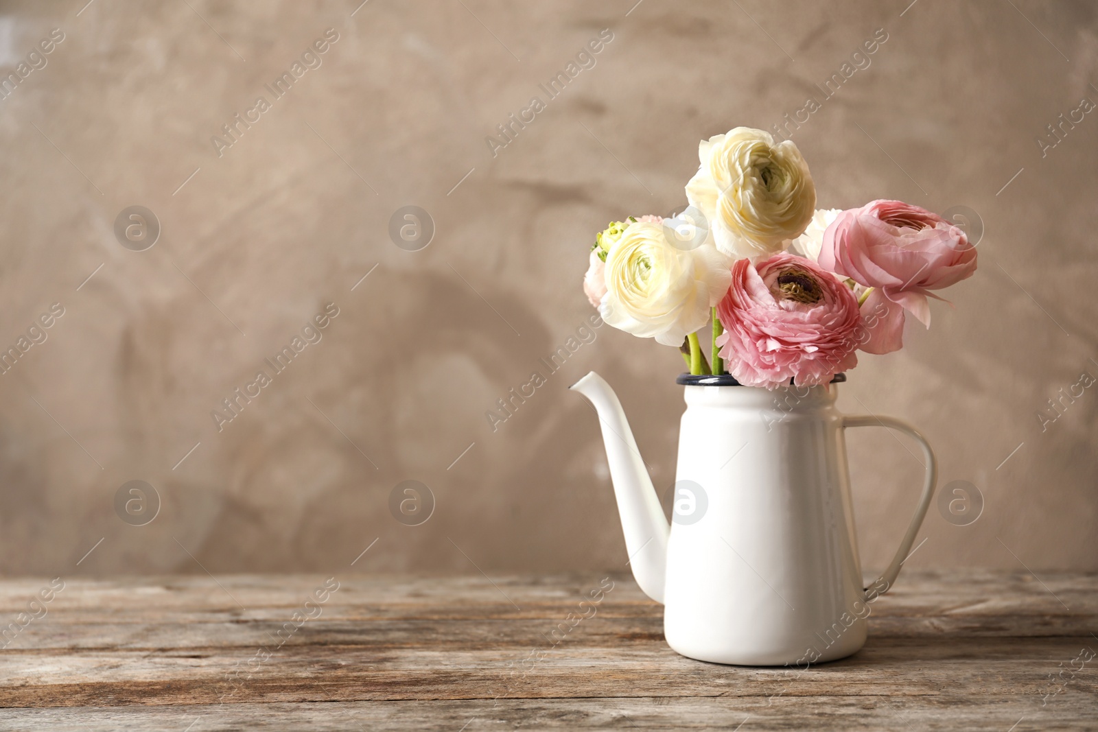 Photo of Vase with beautiful ranunculus flowers on wooden table