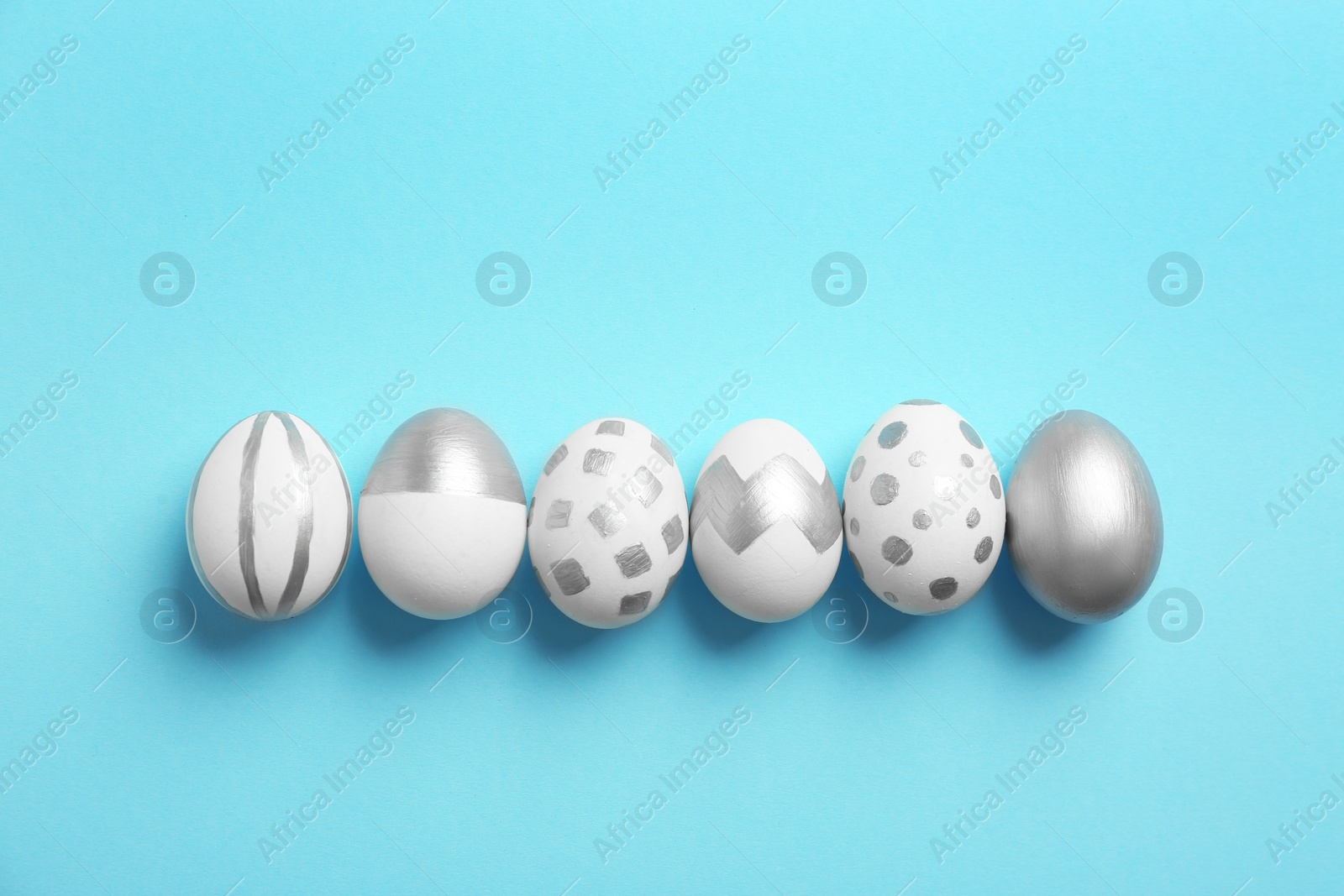 Photo of Painted Easter eggs on color background, top view