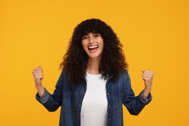 Happy sports fan celebrating on yellow background