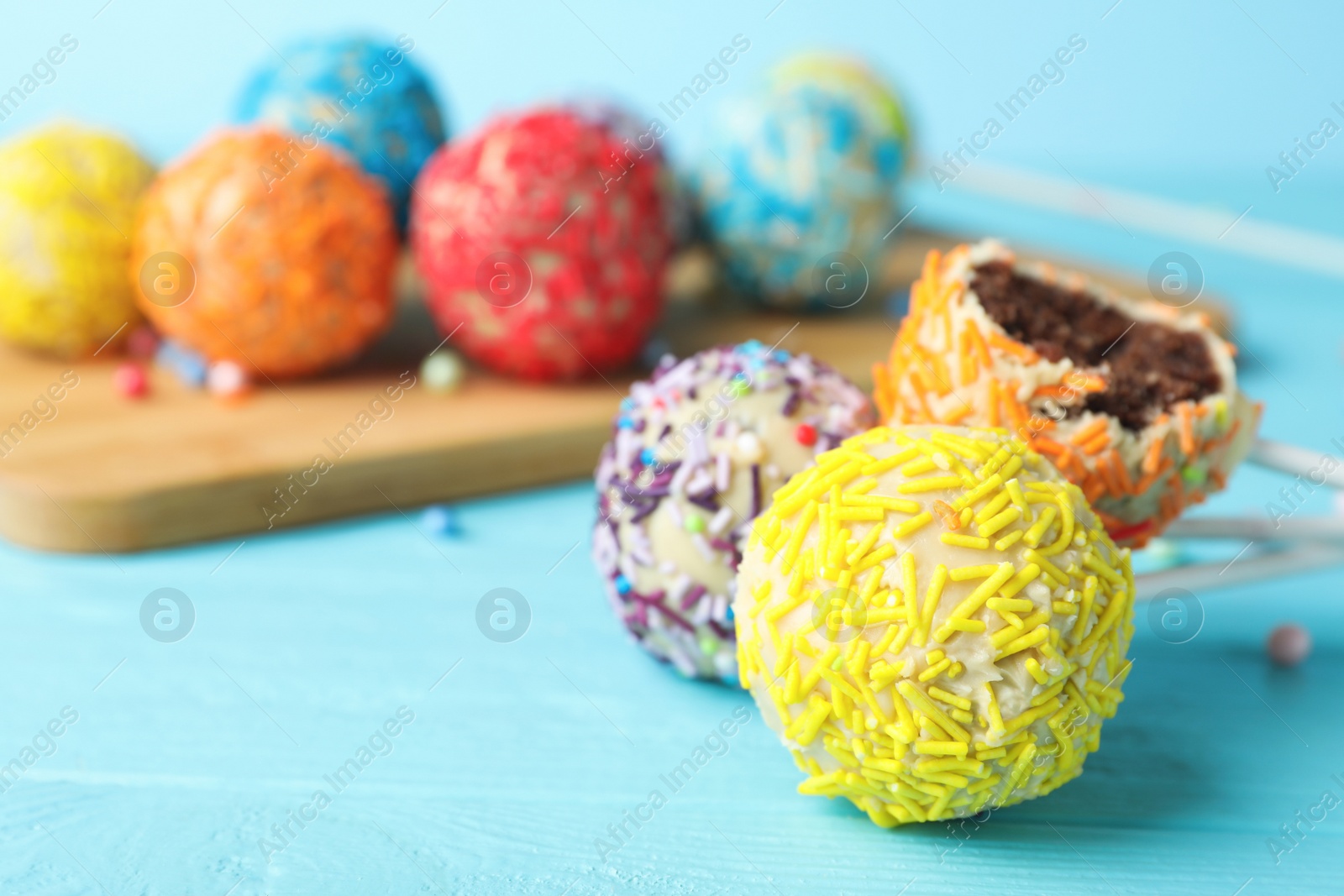 Photo of Yummy colorful cake pops on table, closeup. Space for text