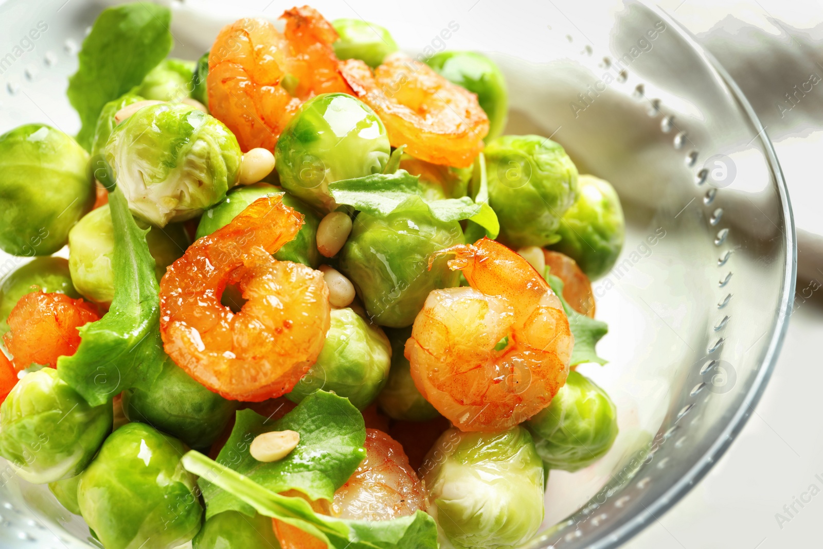 Photo of Bowl of delicious salad with Brussels sprouts and shrimps on table