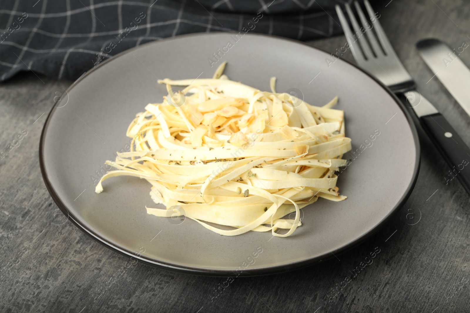 Photo of Fresh white carrot salad served on grey table, closeup