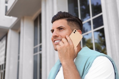 Man talking on modern mobile phone outdoors