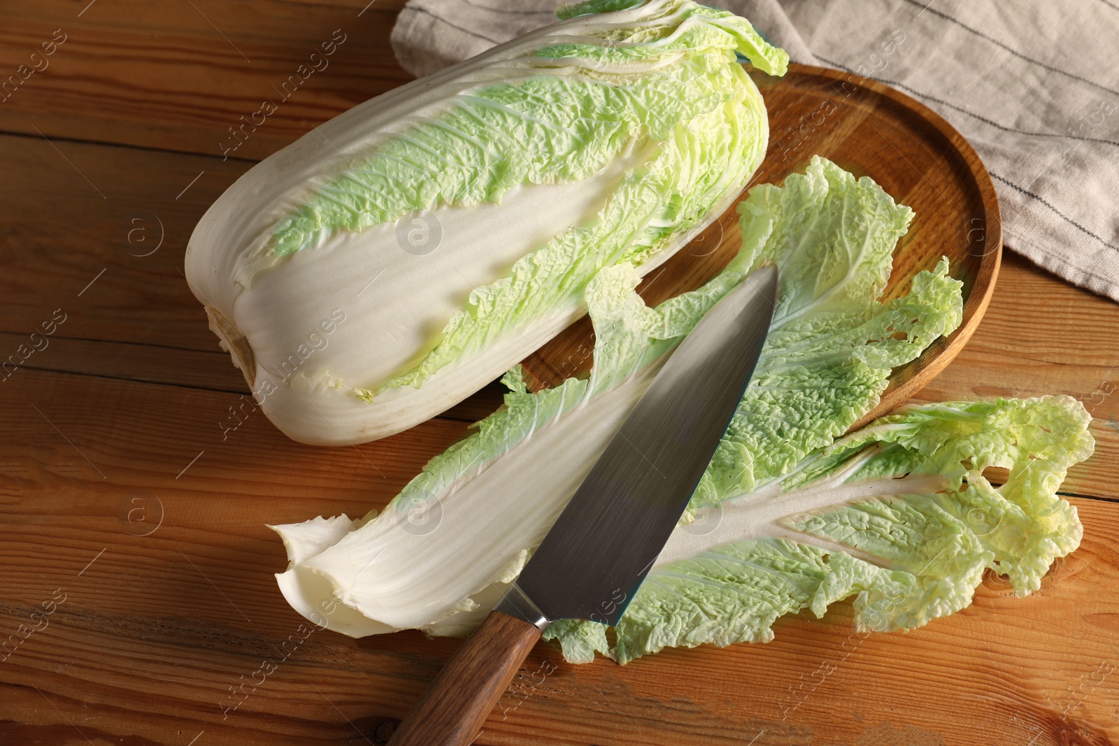 Photo of Fresh Chinese cabbage and knife on wooden table, top view