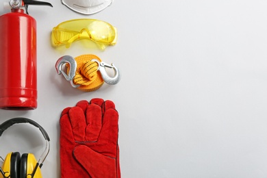 Photo of Flat lay composition with safety equipment and space for text on light background