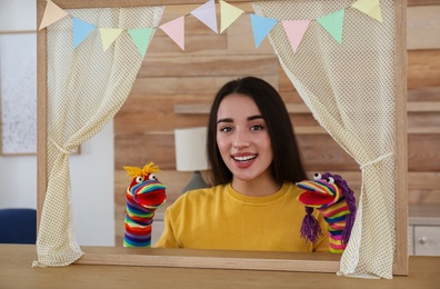 Photo of Young woman performing puppet show at home