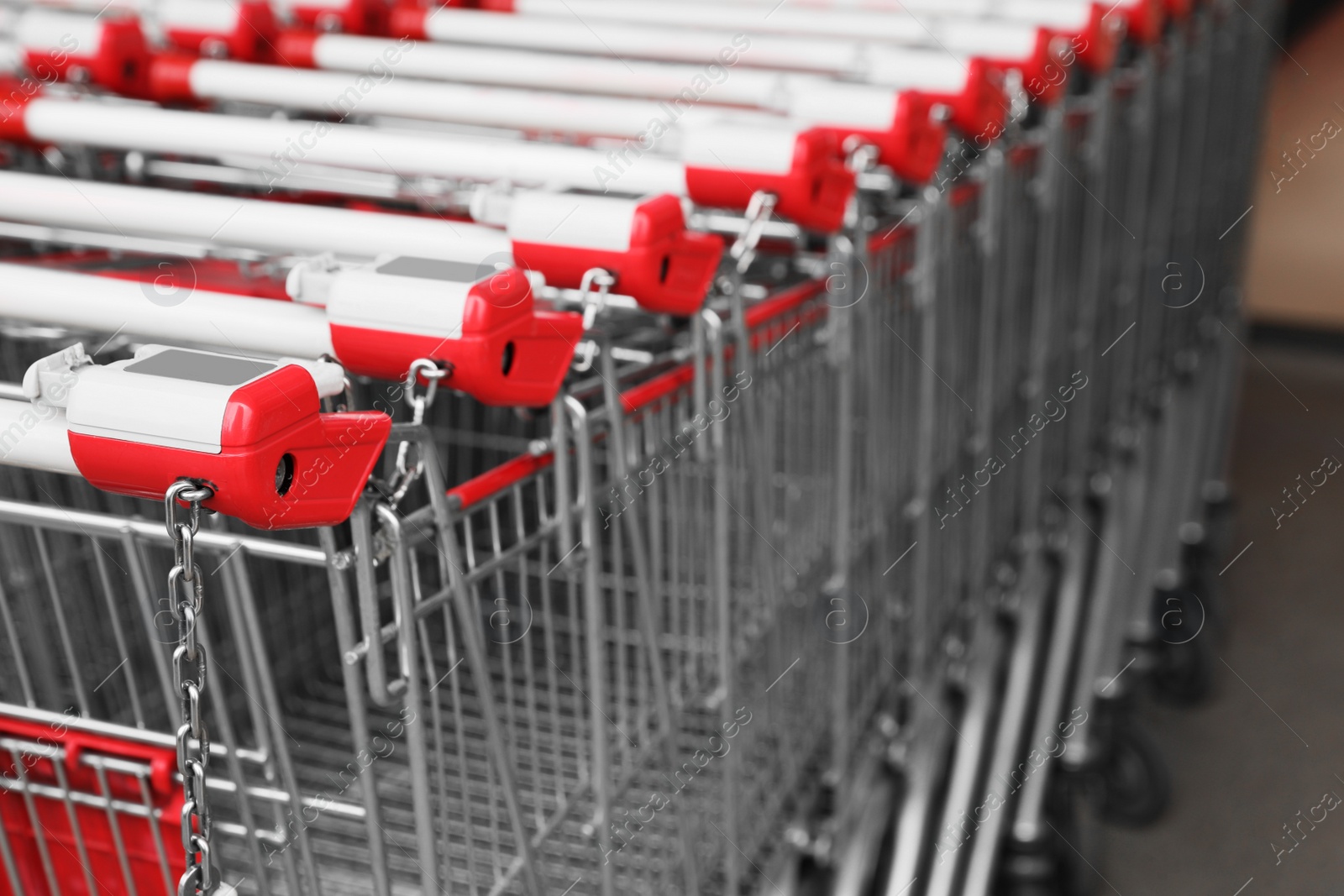 Photo of Many empty metal shopping carts near supermarket outdoors, closeup. Space for text