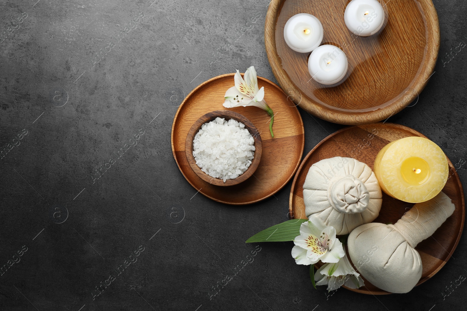 Photo of Flat lay composition with different spa products and lily flowers on grey table. Space for text