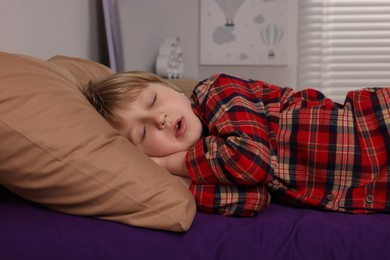 Little boy snoring while sleeping in bed at home