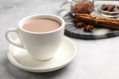 Tasty hot chocolate in cup on grey textured table, closeup