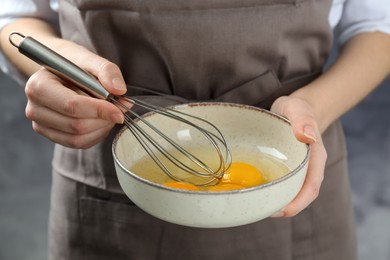 Photo of Woman whisking eggs in bowl, closeup view