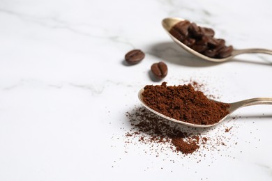Spoons of ground coffee and beans on white marble table, closeup. Space for text