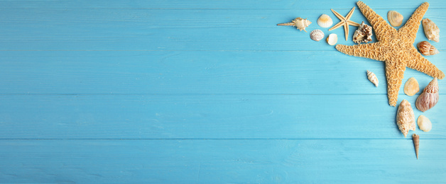 Image of Flat lay composition with beautiful starfishes and sea shells on blue wooden table, space for text. Banner design