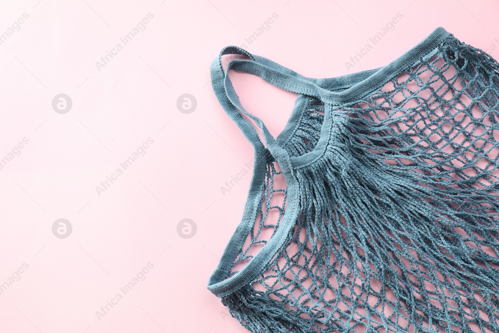 Photo of Blue string bag on pink background, top view. Space for text