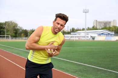 Young man having heart attack while running at stadium