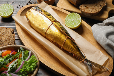 Tasty smoked fish served on wooden table