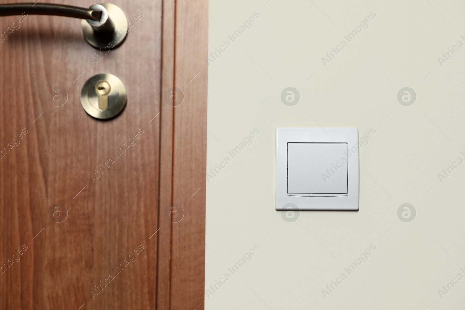 Photo of Modern plastic light switch on white wall indoors