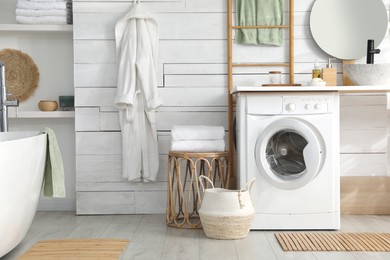 Stylish bathroom interior with modern washing machine