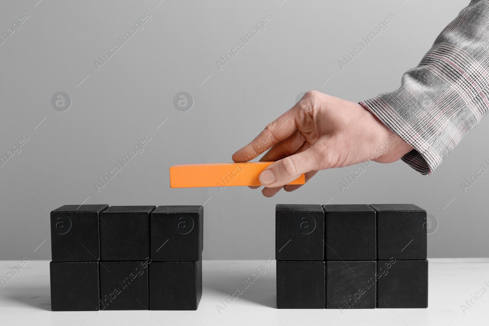 Photo of Businesswoman building bridge with colorful blocks at table, closeup. Connection, relationships and deal concept